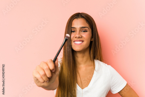 Young caucasian woman holding a eyebrush isolated
