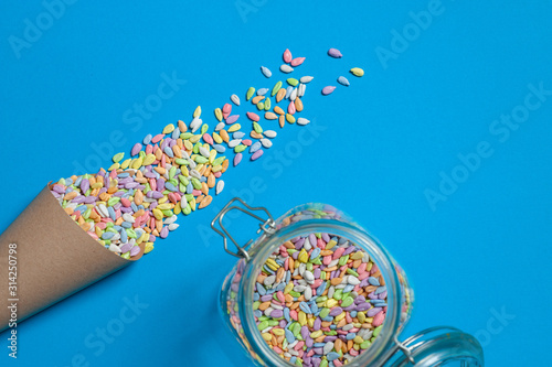  sunflower seeds in colored glaze lie in a bag of craft paper on a blue background