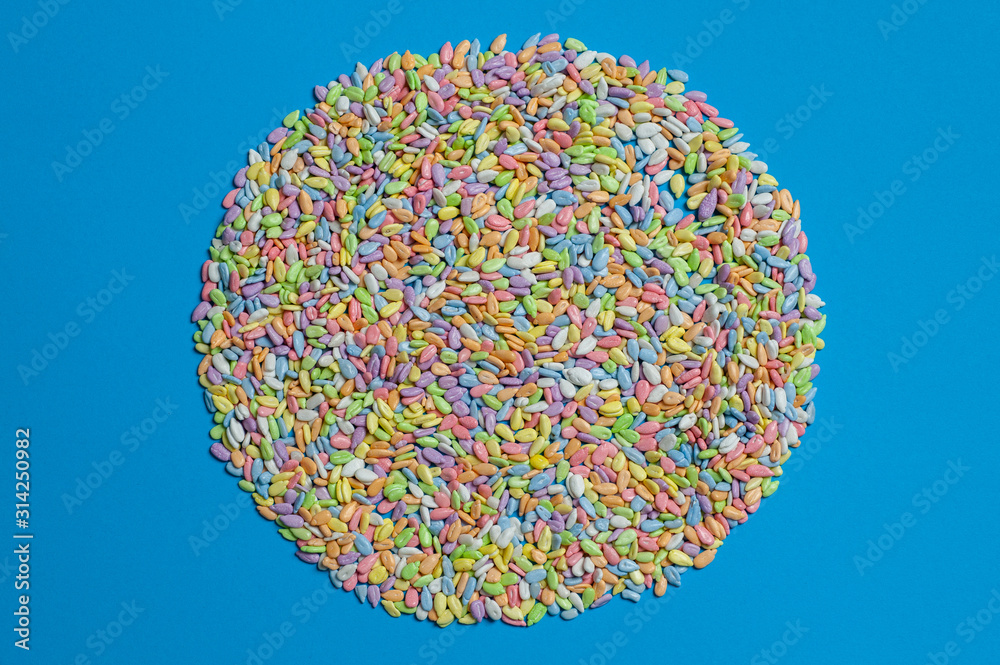 sunflower seeds in colored glaze lie on a blue background sunflower seeds in colored glaze lie on a blue background