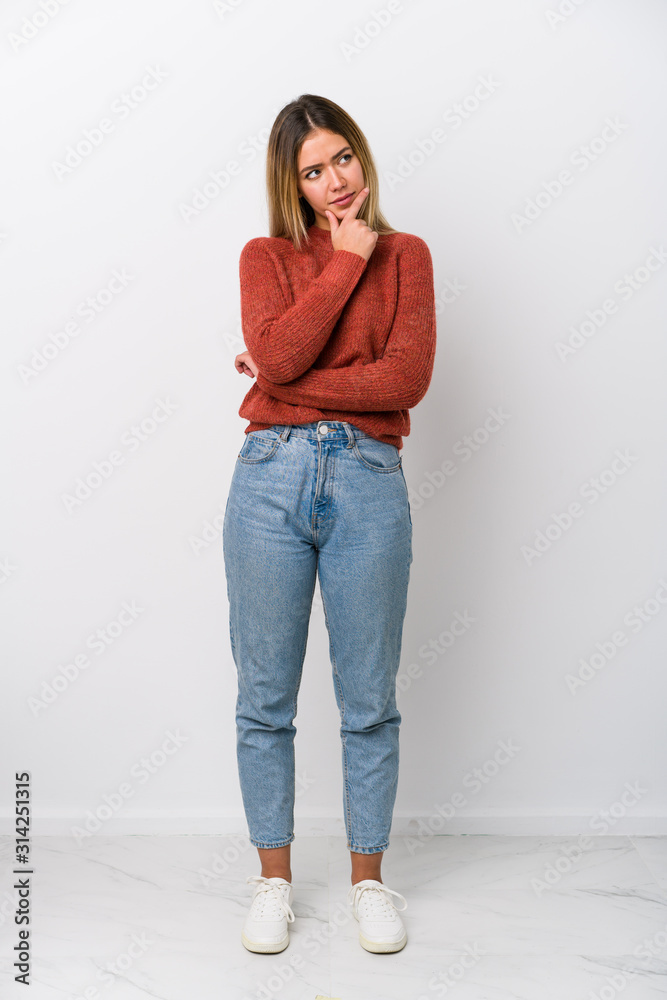 Full body young caucasian woman looking sideways with doubtful and skeptical expression. Full body young caucasian woman looking sideways with doubtful and skeptical expression.