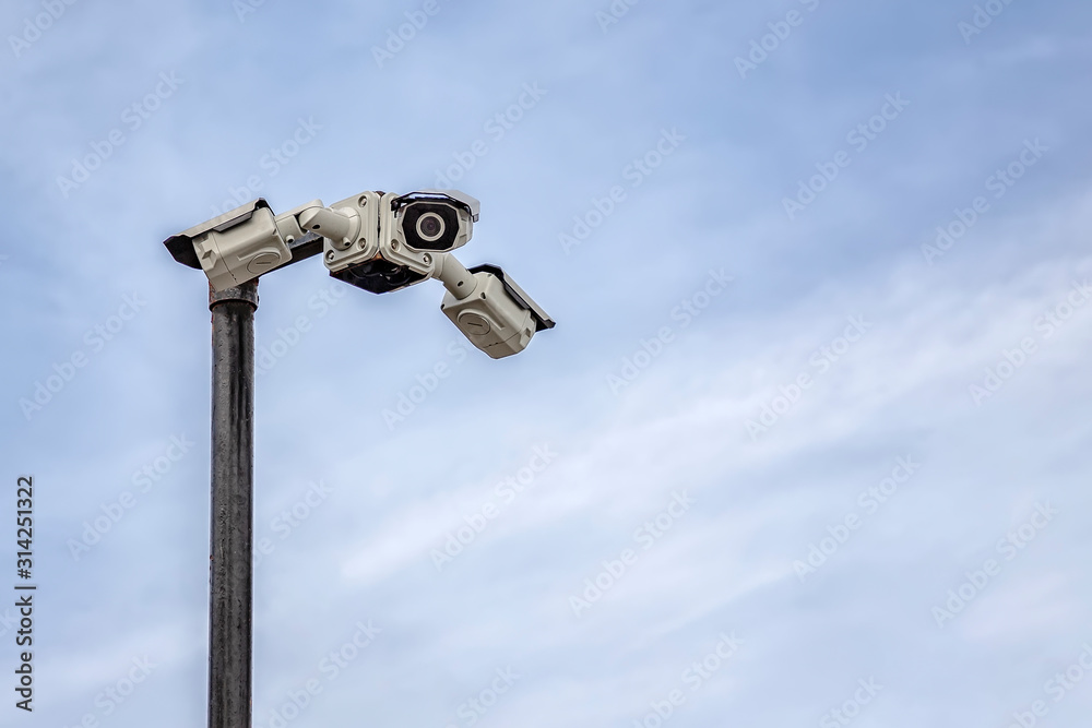 Security CCTV cameras on a pylon in the sky background with copy space Security CCTV cameras on a pylon in the sky background with copy space