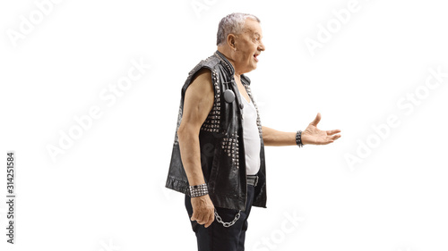 Old punk in a leather vest gesturing with hand