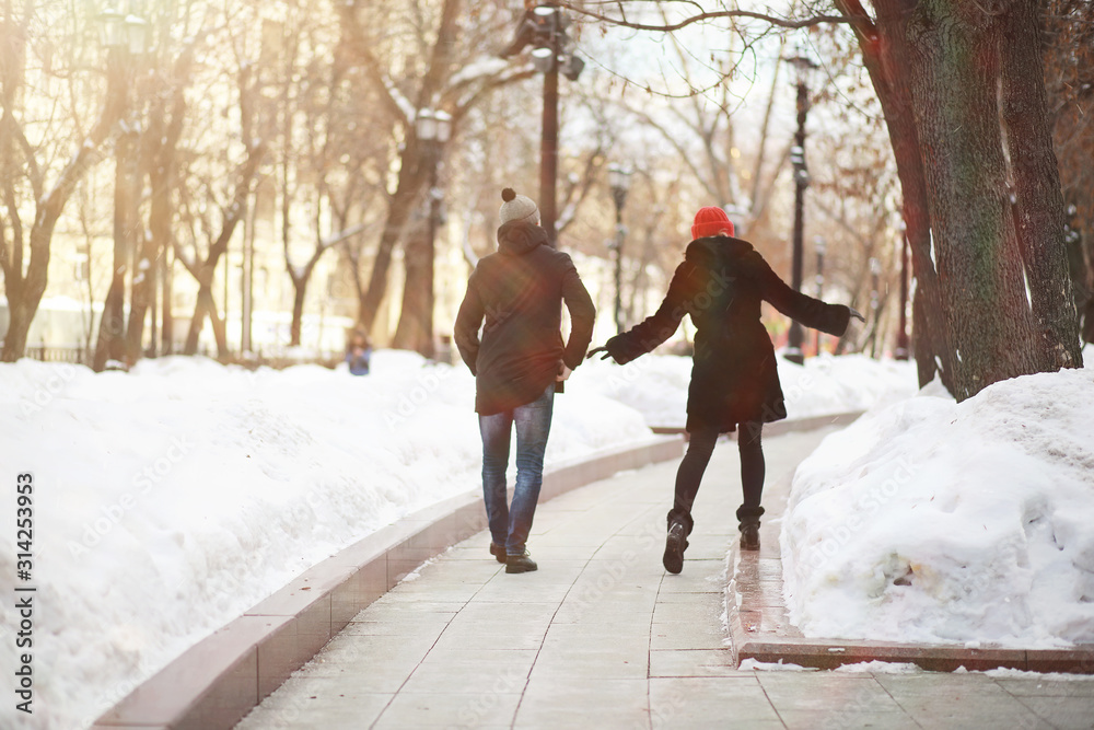 Young couple walking through the winter - obrazy, fototapety, plakaty 