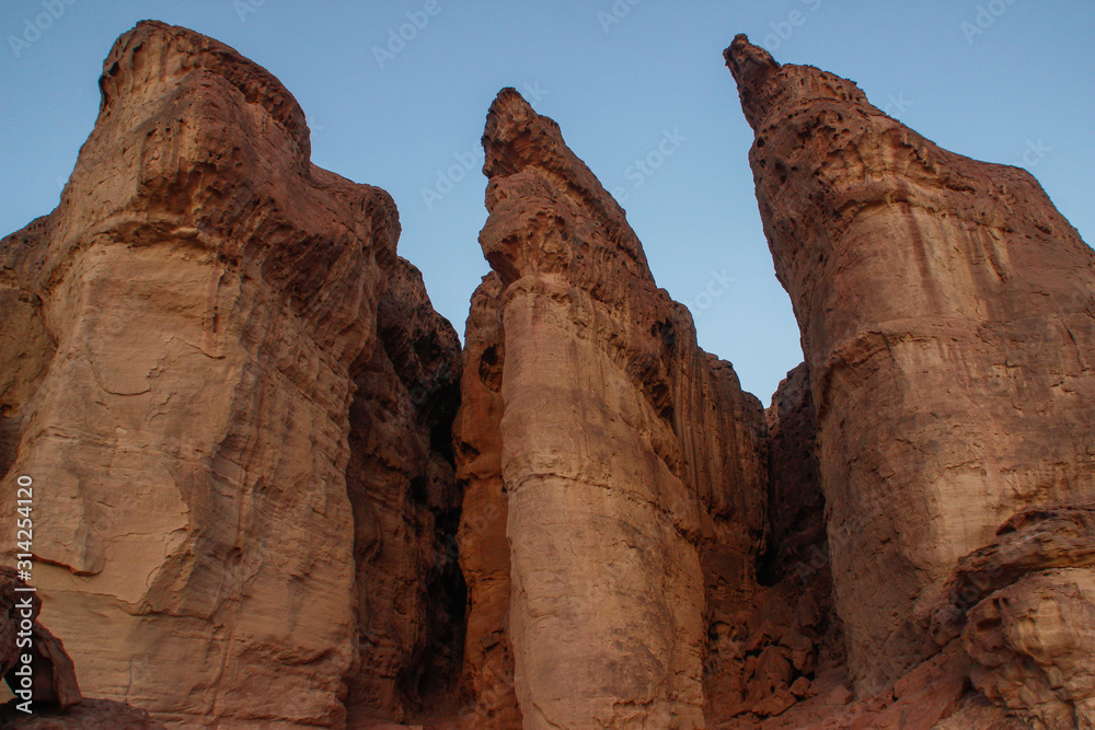 Fototapeta premium The famous Timna National Park in the desert in southern Israel in the Eilat region. Sand cliffs, dry land, red sand in the form of pillars and mushrooms. Sights of Israel.