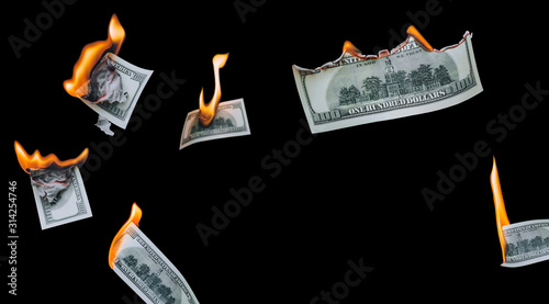 Several 100 dollar bills, falling down, burn on a black background. The concept of bankruptcy, depreciation, devaluation, wastefulness and waste of money. Copy space, isolated. photo