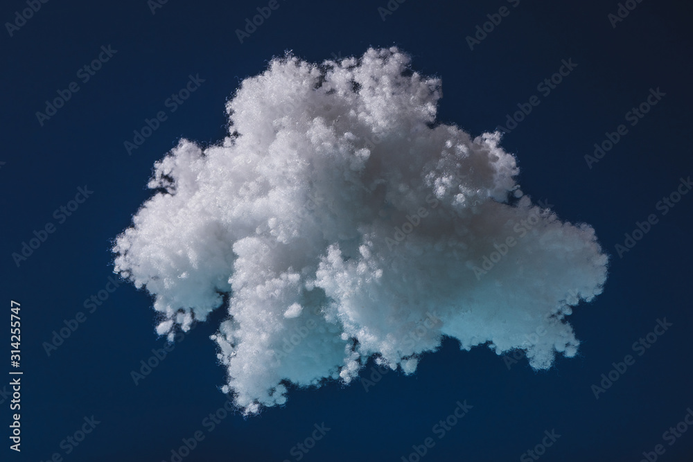 white fluffy cloud made of cotton wool isolated on dark blue
