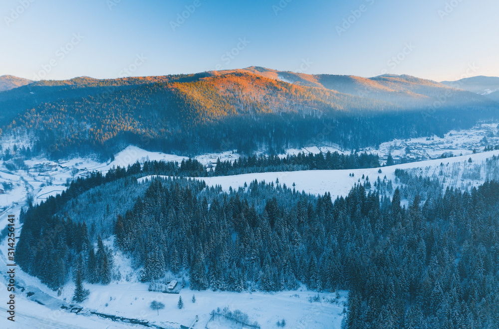Drone photo of winter river and forest in the mountains during sunset