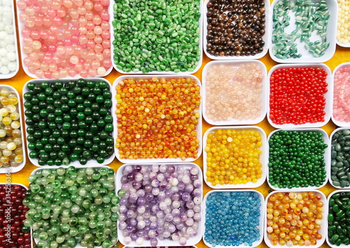 Palette of colors beads in the plastic box close up