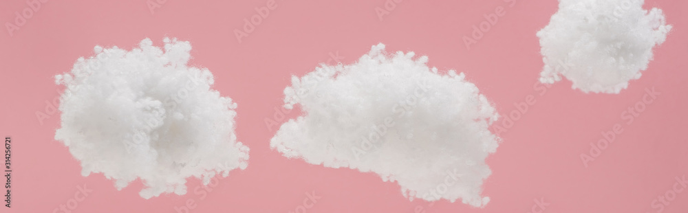 white fluffy clouds made of cotton wool isolated on pink, panoramic shot