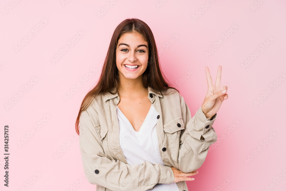 Young caucasian woman posing in a pink background showing number two with fingers. Young caucasian woman posing in a pink background showing number two with fingers.