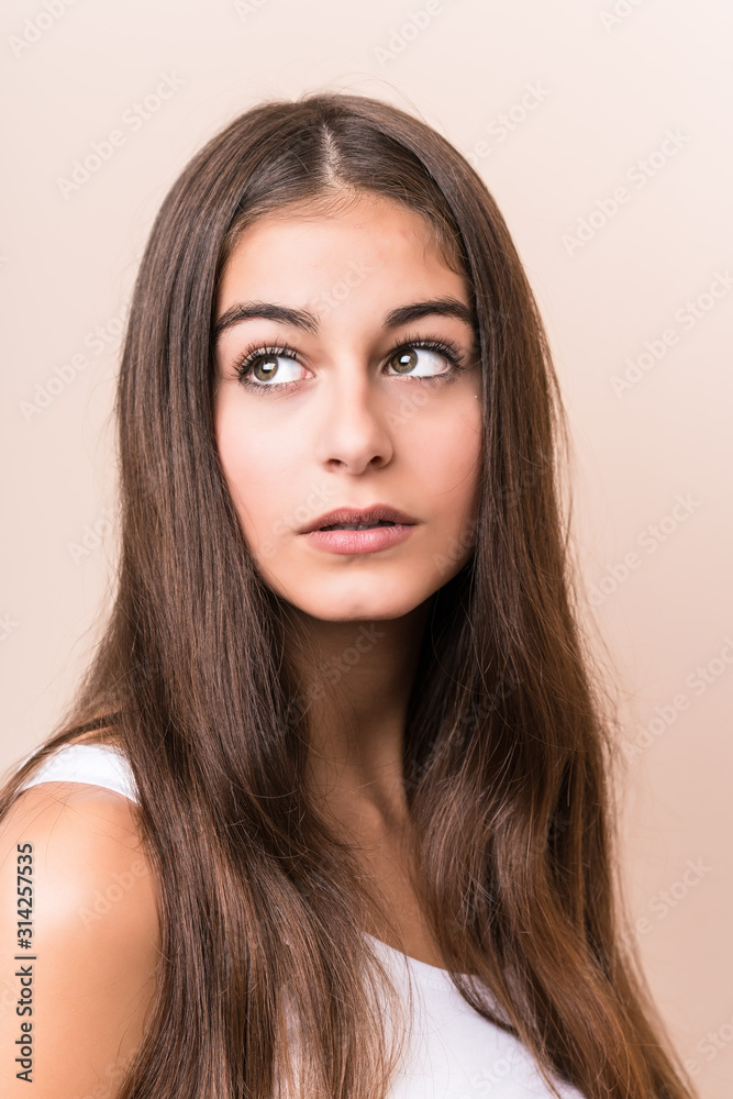 Fototapeta premium Young cute caucasian woman against a beige background