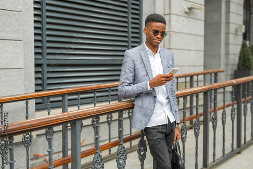 handsome young african man in a suit with a phone in his hand © Alexandr
