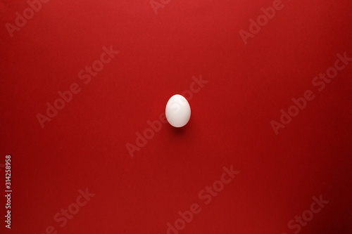 White easter egg with happy easter word, holiday concept. Red background. Top view