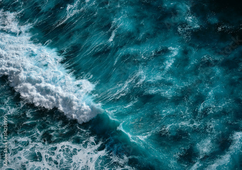Aerial view to seething waves with foam. Blue water background. Dramatic colors photo.