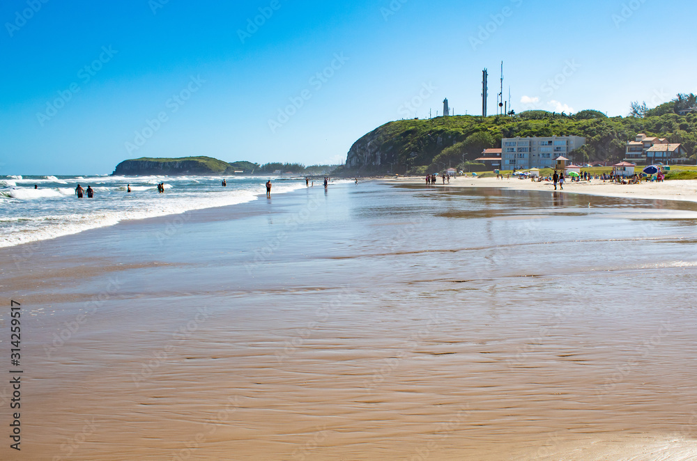 Characteristic cliffs of Torres Beach and reflections of the sky on a sunny day in Prainha