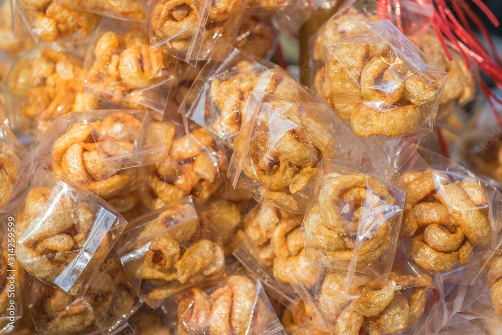 Closeup Pork snack, Pork rind, Pork scratching or Pork crackling are packaging in the transparent plastic bags for sale in local street market of Thailand