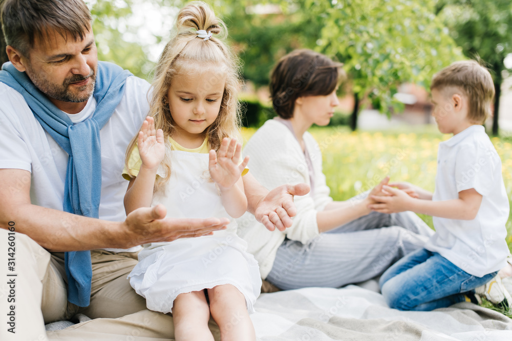 Parents playing with their kids at the picnic.