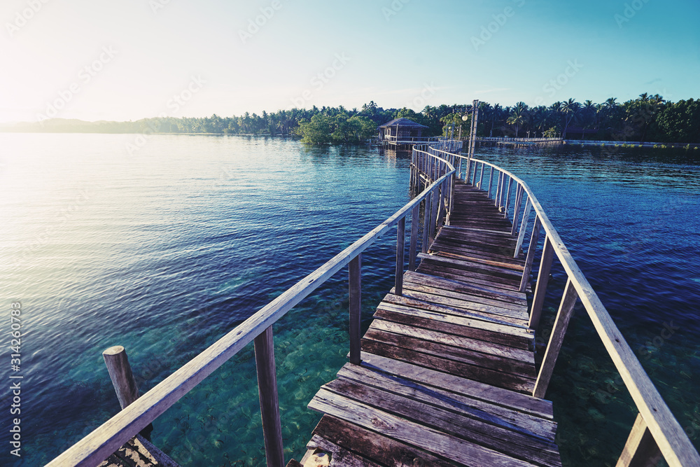 Fototapeta premium Beautiful landscape. Sunset on the seashore. Wooden bridge on the beach, Siargao Island, Philippines.