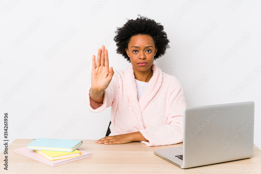 Middle aged african american woman working at home isolated standing with outstretched hand showing stop sign, preventing you. Middle aged african american woman working at home isolated standing with outstretched hand showing stop sign, preventing you.