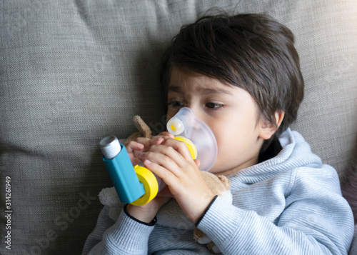 Cuadro en lienzo Poor boy tired from chest coughing holding inhaler mask, Child closing his eyes