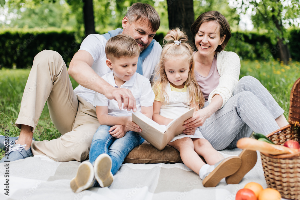 Portrait of a family at the picnic reading a book. Portrait of a family at the picnic reading a book.