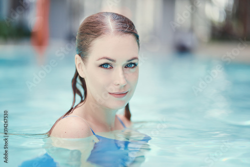Enjoying vacation. Sensual portrait of  beautiful young woman in swimming pool.