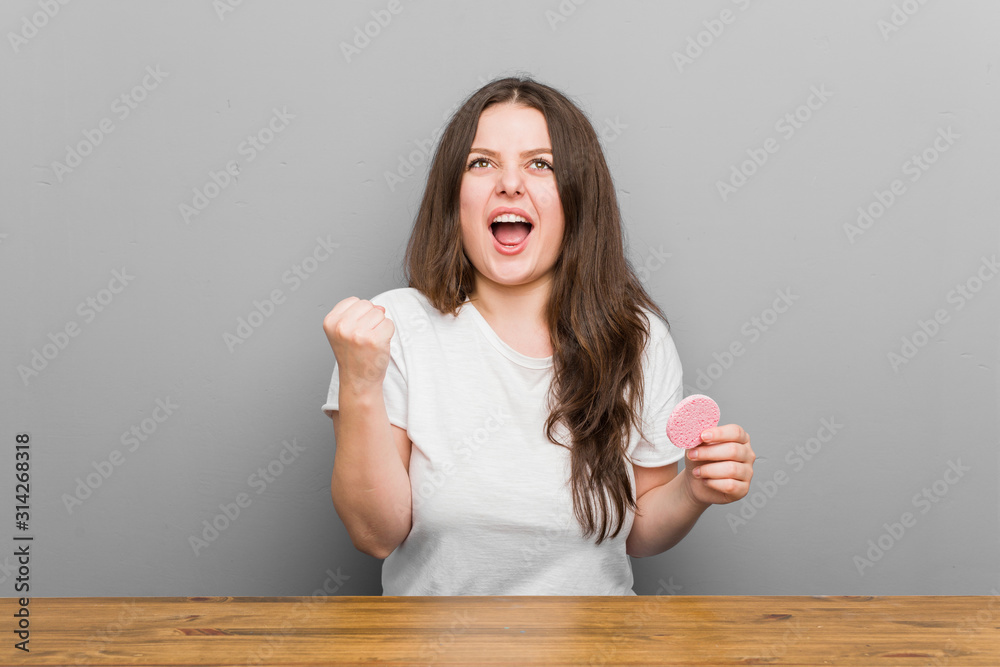 Young plus size curvy woman holding a facial sponge cheering carefree and excited. Victory concept. Young plus size curvy woman holding a facial sponge cheering carefree and excited. Victory concept.