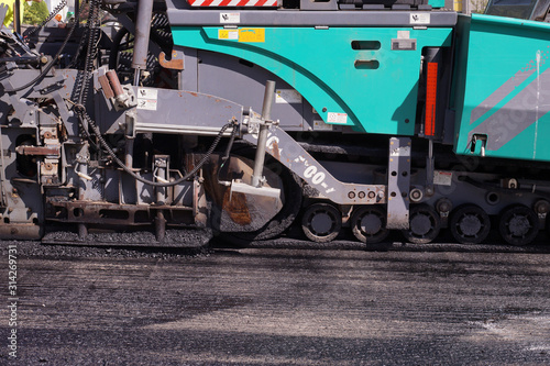 Heavy asphalt laying machine during work. Road construction.