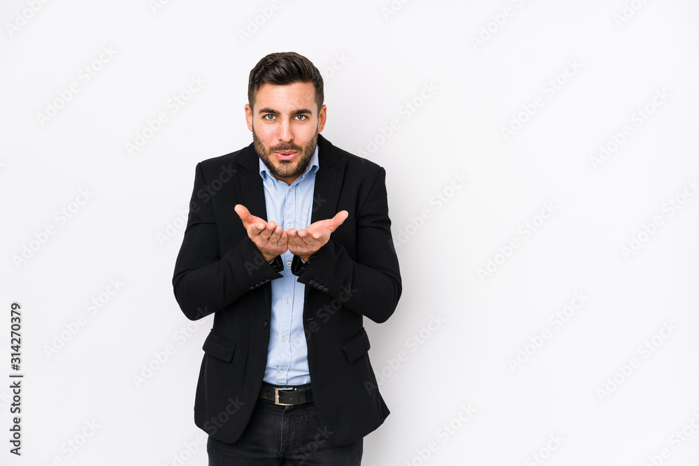 Young caucasian business man against a white background isolated folding lips and holding palms to send air kiss. Young caucasian business man against a white background isolated folding lips and holding palms to send air kiss.