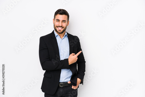 Young caucasian business man against a white background isolated smiling and pointing aside, showing something at blank space. photo