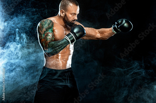 Fitness and boxing concept. Boxer  man fighting or posing in gloves on black background. Individual sports recreation.