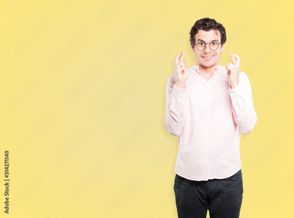 Happy young man doing a crossed fingers gesture Happy young man doing a crossed fingers gesture