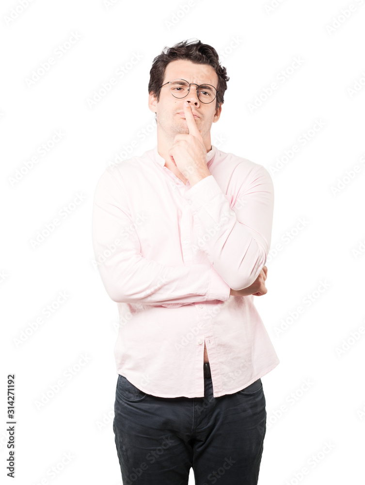 Concentrated young man making a gesture of distrust Concentrated young man making a gesture of distrust