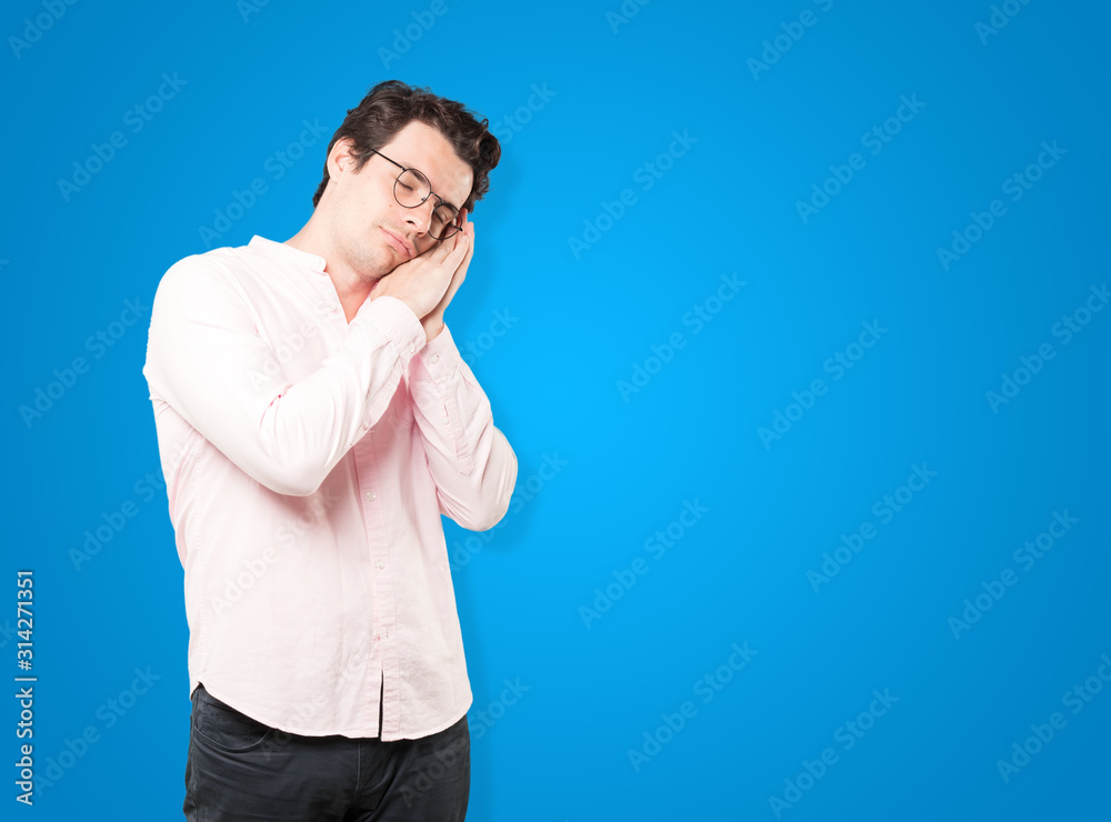 Relaxed young man making a gesture of sleep Relaxed young man making a gesture of sleep