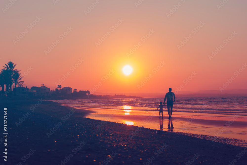Man and kid silhouette going along sea shore on sun set backround, vacation evening. Parent and child, Father's day, Family with daughter, travelling with baby, girl, Holiday. Horizontal. Violet tone,
