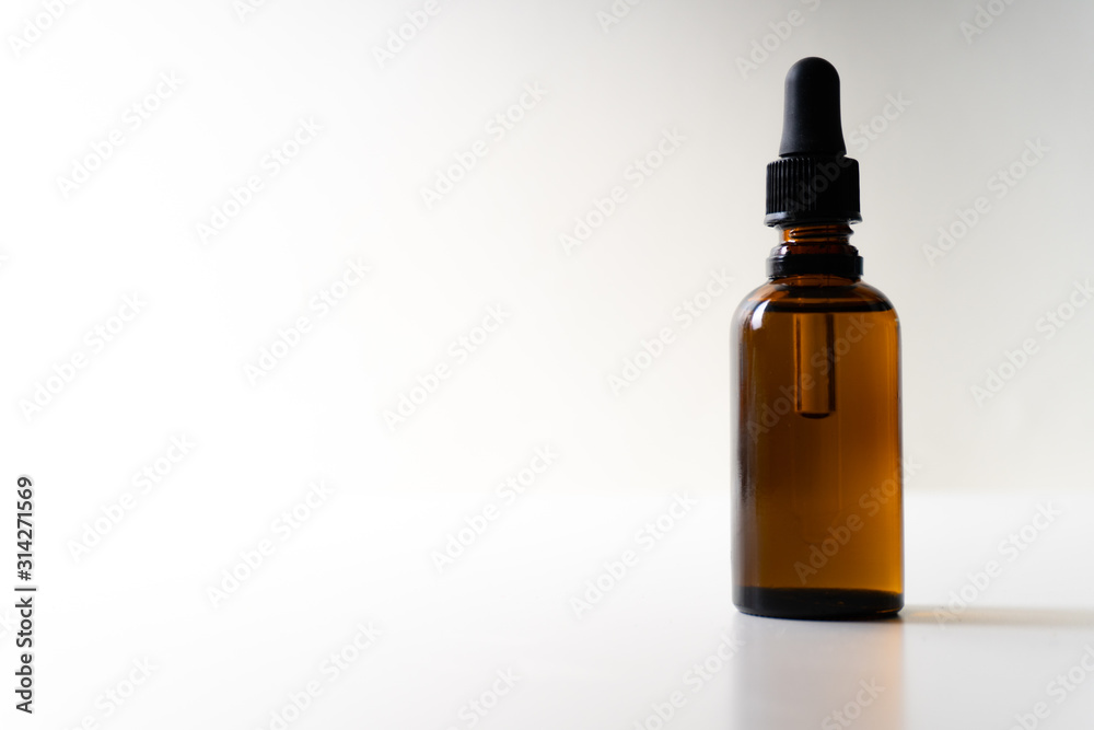 A small bottle with a dropper full of CBD oil or any other oil on white background