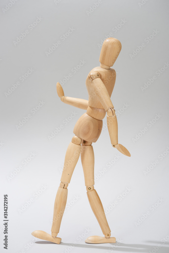 Wooden doll with hinges on grey background Wooden doll with hinges on grey background