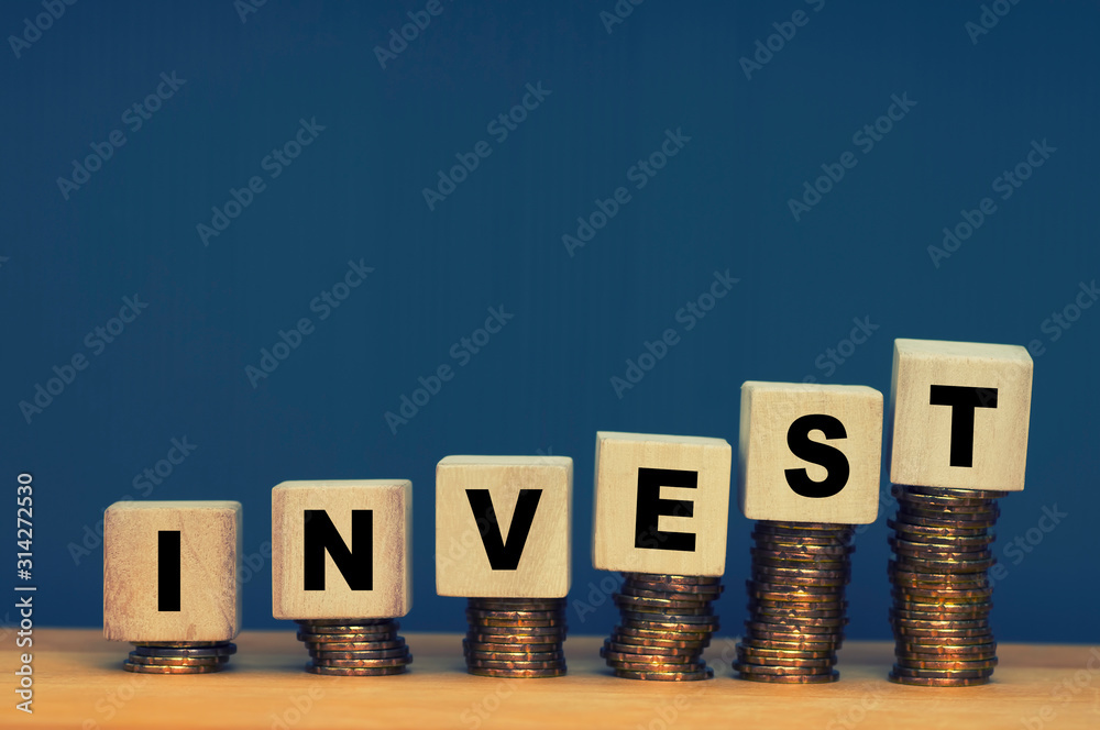 Finance And Investment Concept with wooden block stacked on coins Finance And Investment Concept with wooden block stacked on coins