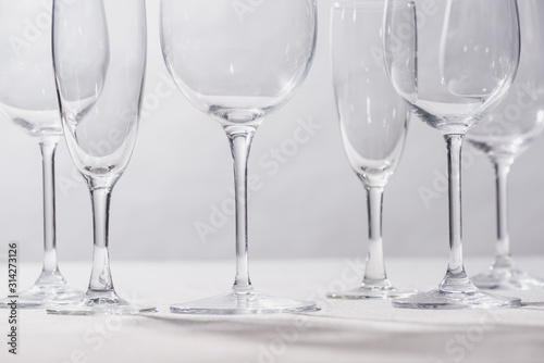 Shiny clear glasses on white surface isolated on grey