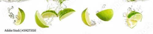 Photo Fresh lime dropped into water with splash isolated on white