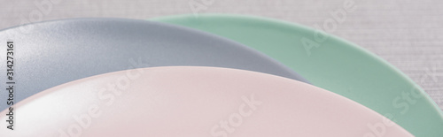 Colorful plates on grey surface, panoramic shot