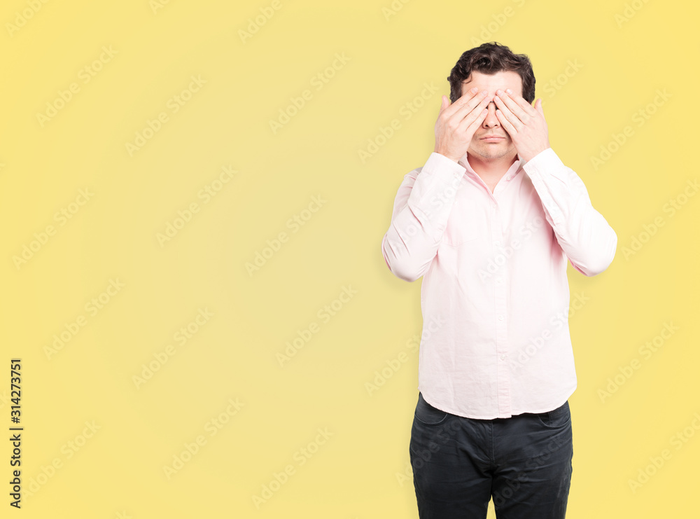 Young man covering his eyes with his hands