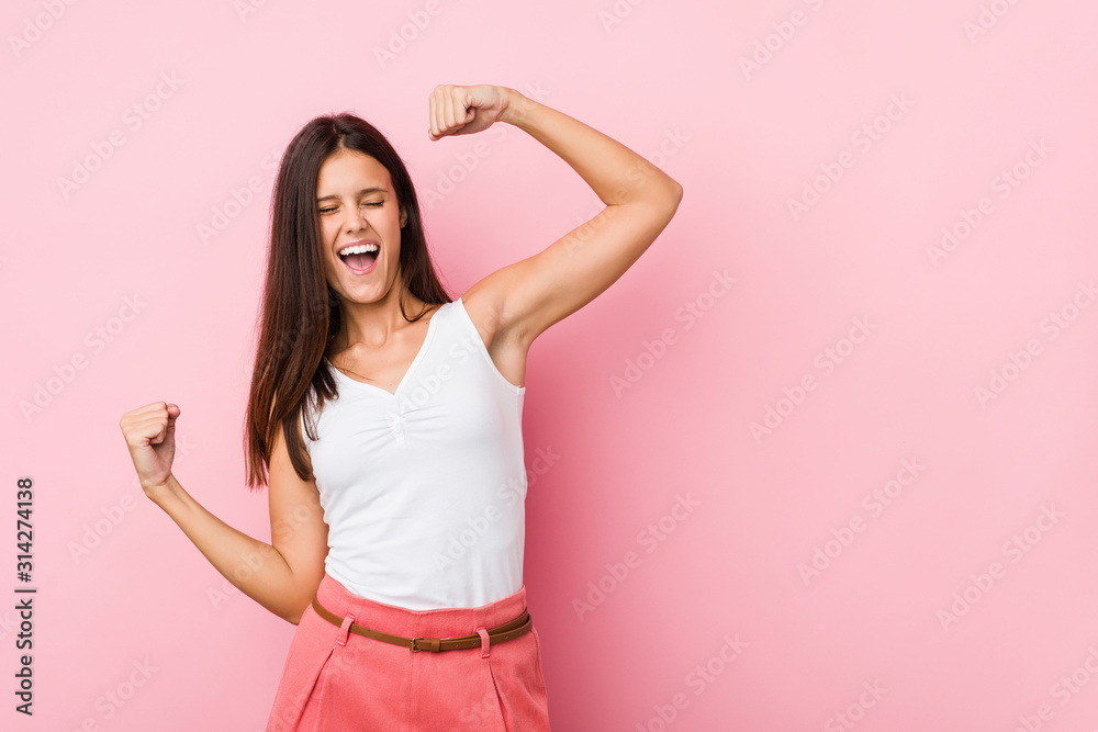 Young cute woman raising fist after a victory, winner concept. Young cute woman raising fist after a victory, winner concept.