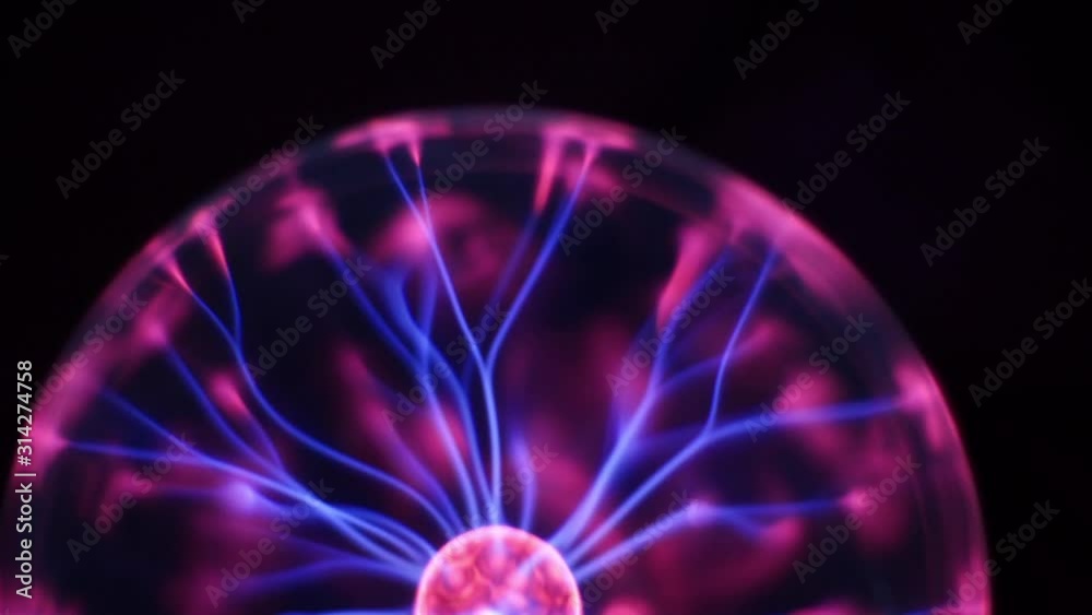 Plasma lightning ball moves randomly and stops in the centre on a black background. Tesla discharge lamp, Plasma globe with high voltage lightning. Inert gas discharge tube changing color Plasma lightning ball moves randomly and stops in the centre on a black background. Tesla discharge lamp, Plasma globe with high voltage lightning. Inert gas discharge tube changing color