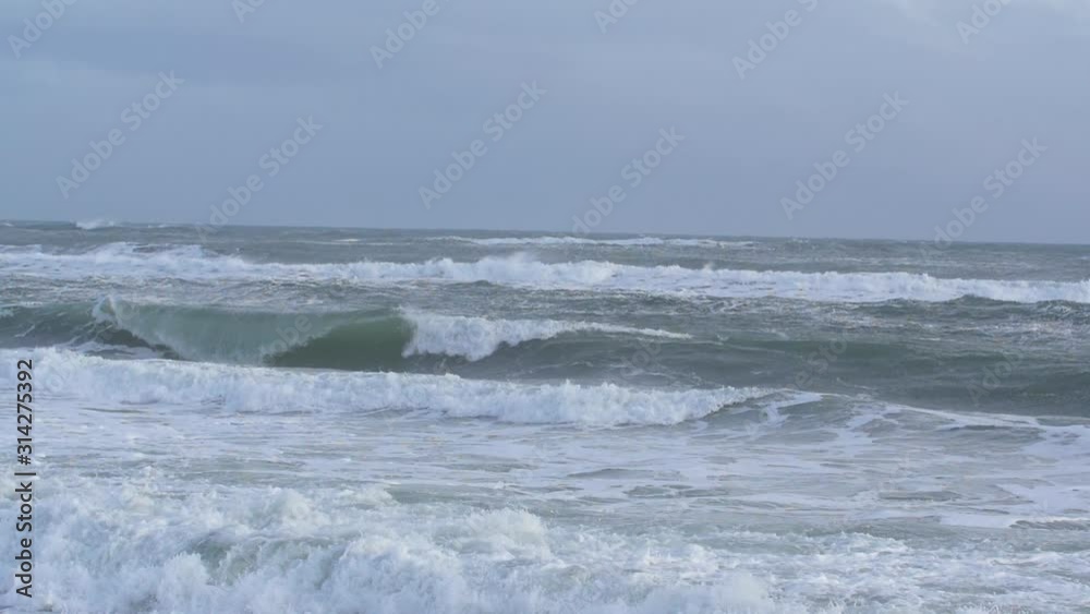 Shot very slow-motion, in Kamchatka, strong waves raging in the Pacific ocean in winter in daylight Shot very slow-motion, in Kamchatka, strong waves raging in the Pacific ocean in winter in daylight