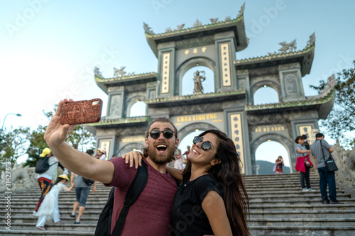 Happy tourist couple taking a selfie on a popular travel destination in Da Nang Vietnam