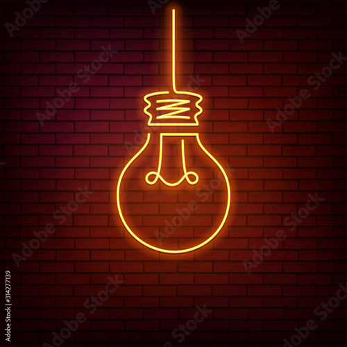 Yellow neon sign with a light bulb on a red brick wall background.
