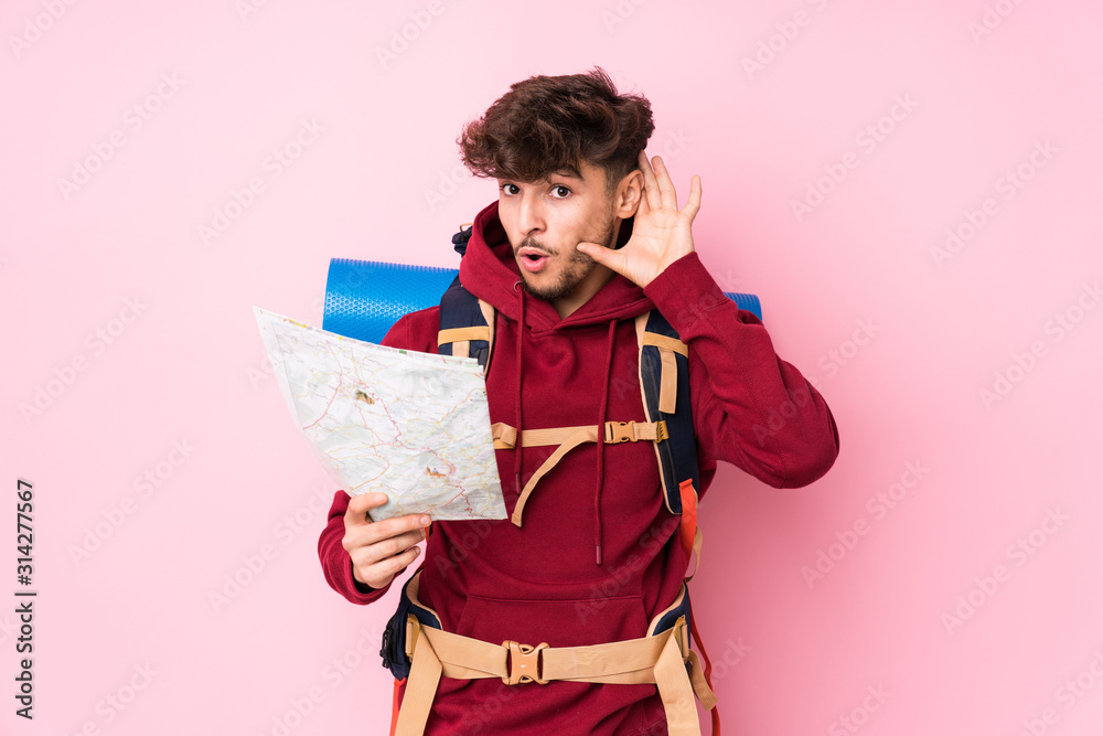 Young arab traveler man holding a map trying to listening a gossip. Young arab traveler man holding a map trying to listening a gossip.