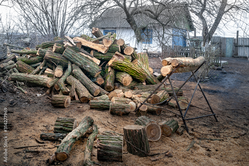 Sawn old logs in a rustic courtyard. Stack of logs at a sawmill. Stack firewood. Logs for the fireplace. Harvesting wood. Forest for the winter.