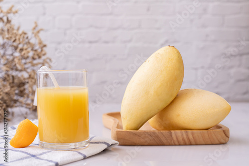 Fototapeta Naklejka Na Ścianę i Meble -  Glass of mangoes juice on table, Sweet dessert.